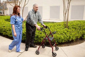 Nursing Walking with an Elderly Man with a Walker Nursing Walking with an Elderly Man with a Walker