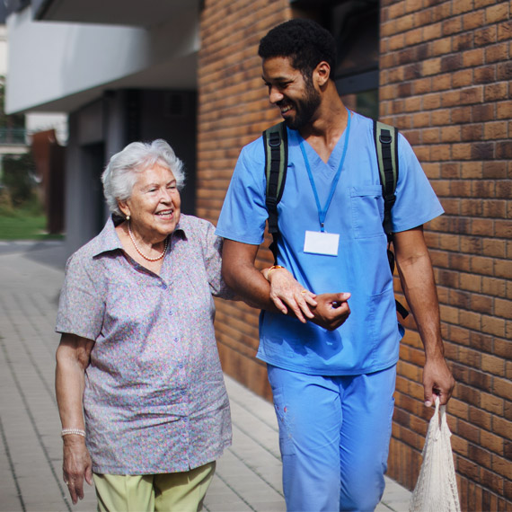 An elderly woman recieiving help, companionship and the supportive services offered by a home care and senior assistance of Qualicare Home Care